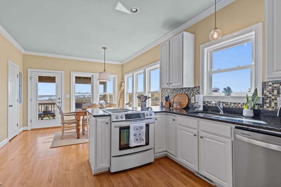 Fully equipped kitchen with natural light and coastal views at Marsh House