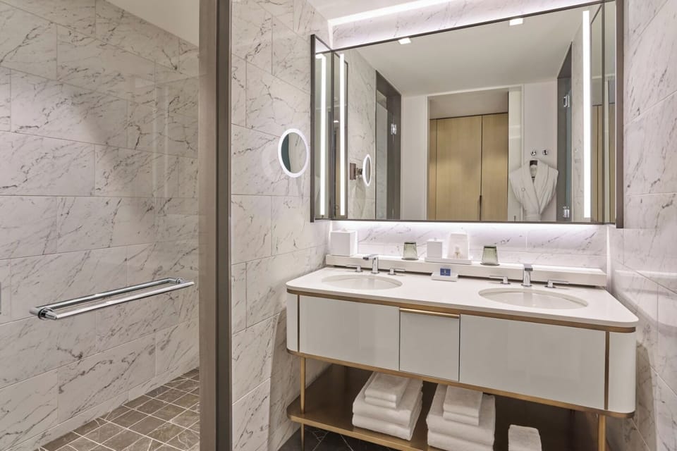 Refresh in a marble bath with bright, spa-like lighting.
