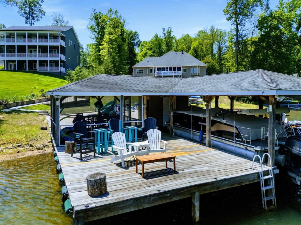 Lakefront - Adirondack chairs gather on the open dock deck beside the covered boat slip, swim ladder ready for a quick dip.