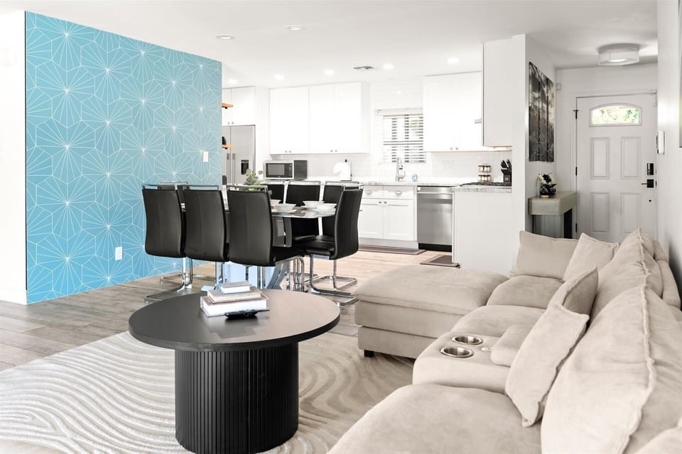 Bright open-concept living space with modern kitchen and stylish blue accent wall
