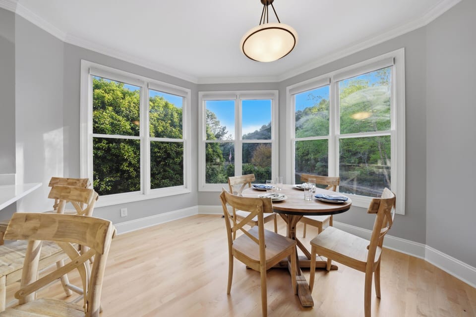 Cozy dining nook with bay‑window views of the surrounding greenery.
