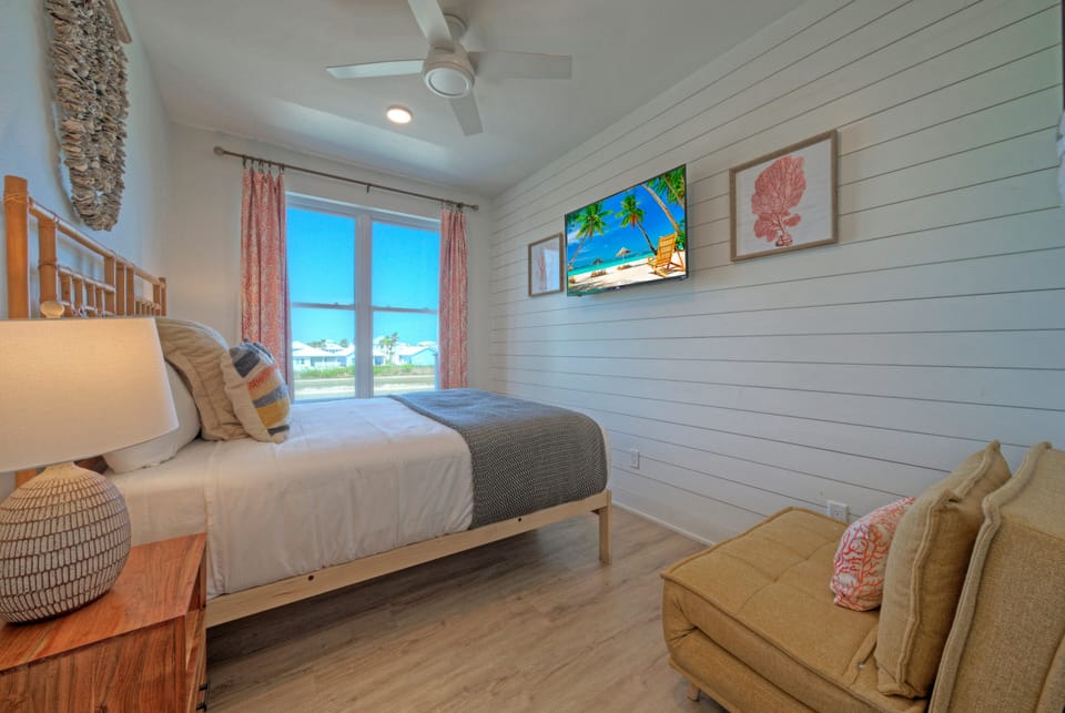 Bedroom 2 features a queen bed, a twin-sized fold-out sleeper chair and a TV.