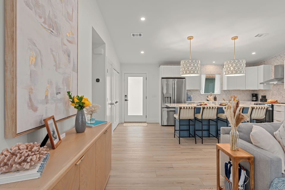 Bright open‑concept kitchen and living area with warm wood tones, soft neutrals, and a welcoming modern flow.