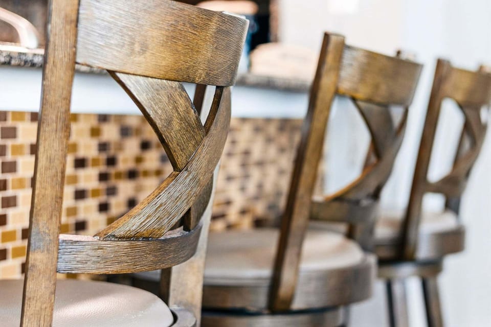 High-back wooden chairs provide a comfortable place to sit and chat while meals are prepared.