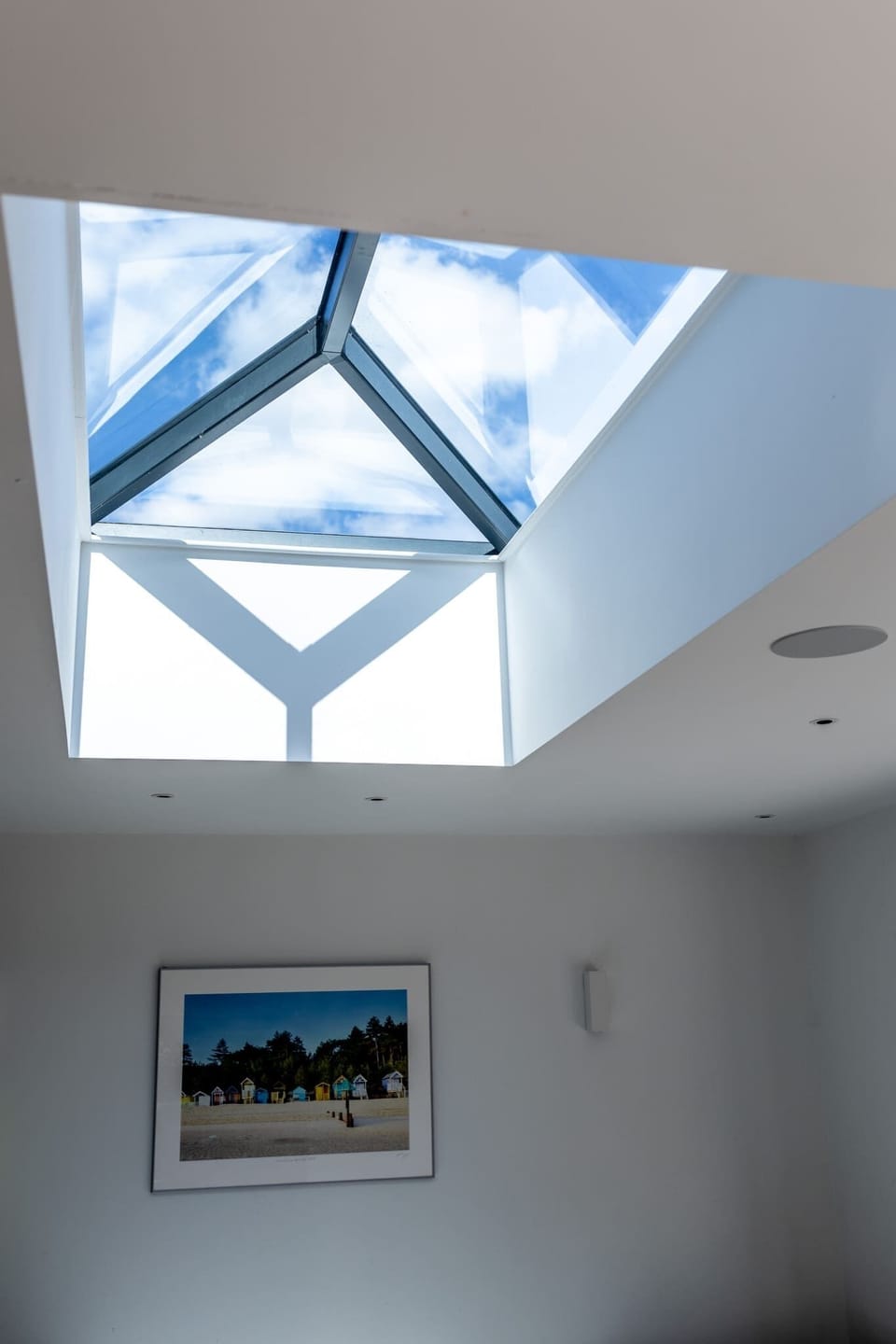 Large skylight fills the space with natural light, creating a bright and airy atmosphere.
