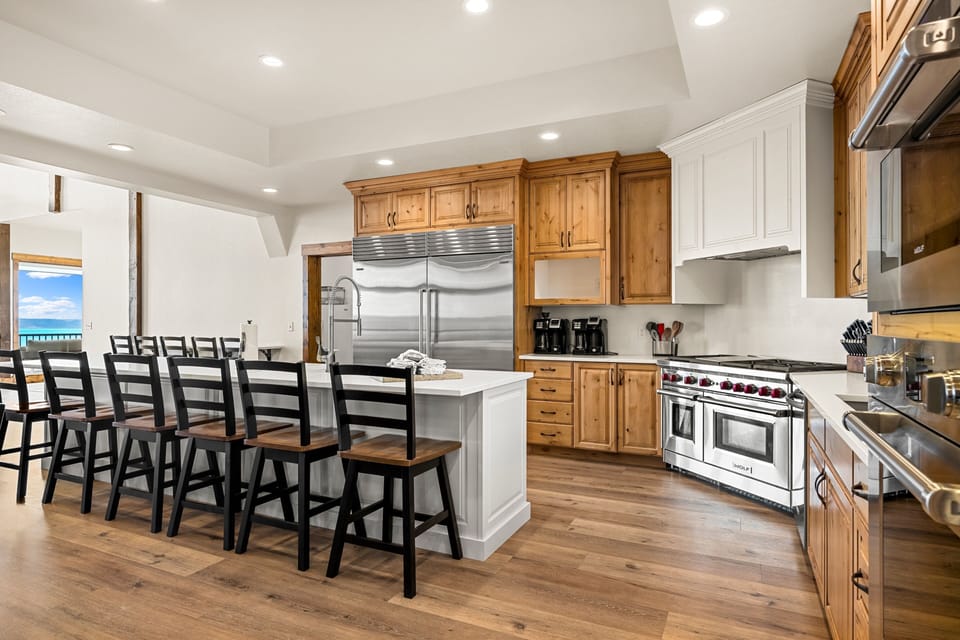 Your gourmet kitchen boasts professional-grade appliances, a spacious island with seating for ten, and stunning ocean views through the nearby windows—perfect for gathering and creating meals together.