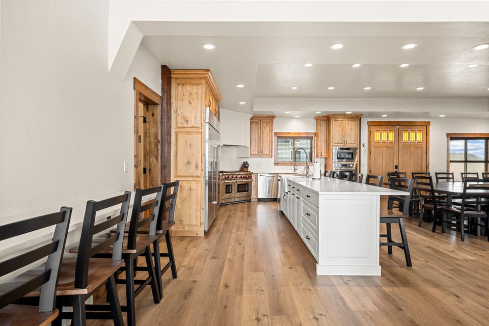 Your spacious chef's kitchen welcomes you with gleaming countertops, a generous island, and warm wood tones throughout. Gather around the table or perch at the bar—there's room for everyone to share meals together.
