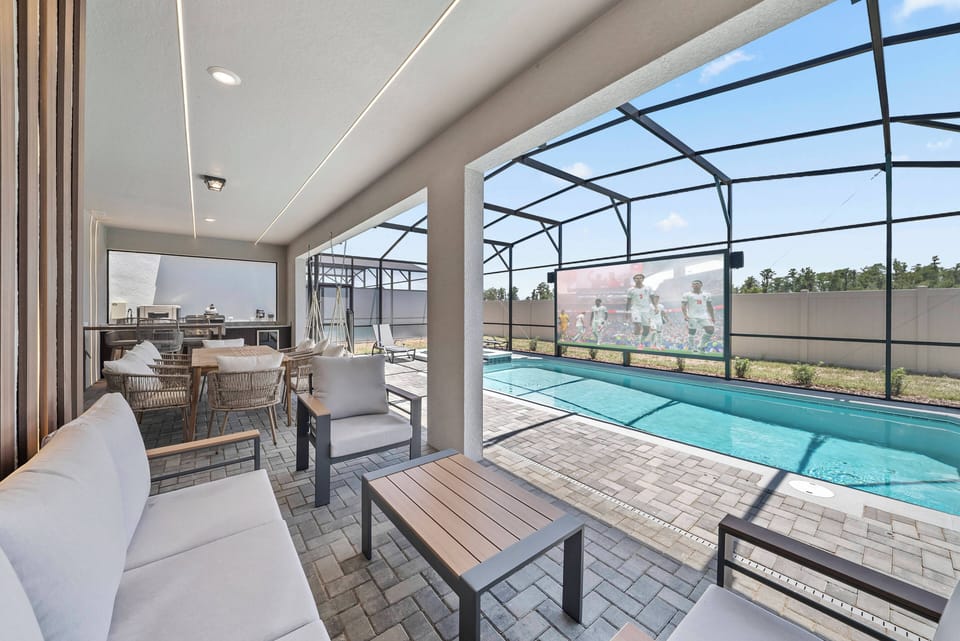 Discover our inviting lounge that beautifully merges indoor and outdoor spaces, featuring chic neutral furniture. Large windows highlight the pool area, filling the space with natural light and creating a warm, welcoming ambiance.