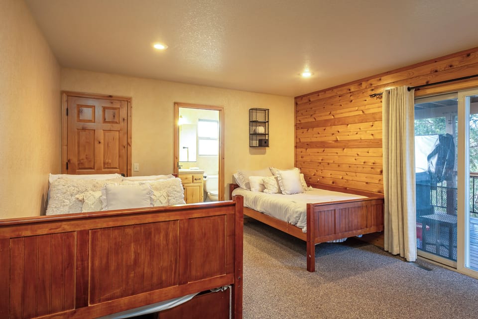 Rest easy in this charming twin bedroom with beautiful wood accents and direct balcony access for morning coffee.