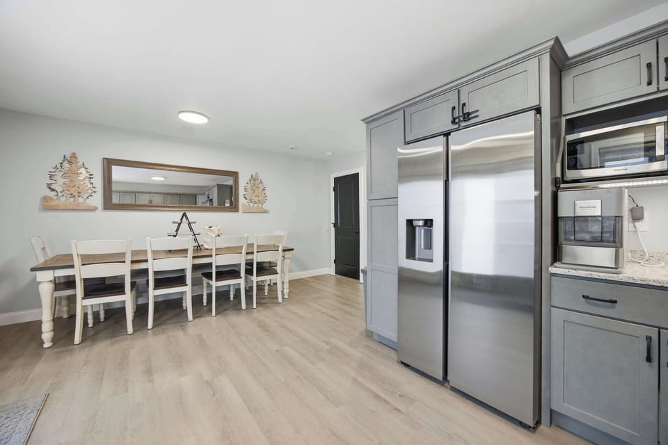The kitchen opens into the dining area, where the farmhouse table seats six for easy family-style meals.