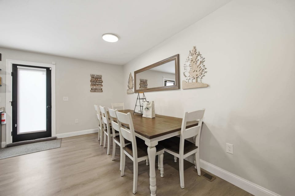 The farmhouse dining table seats six, with natural light and an easy flow into the kitchen.