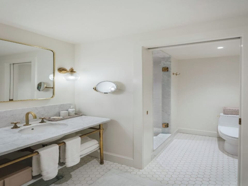 Refresh in a bright marble bath with luxe brass fixtures.