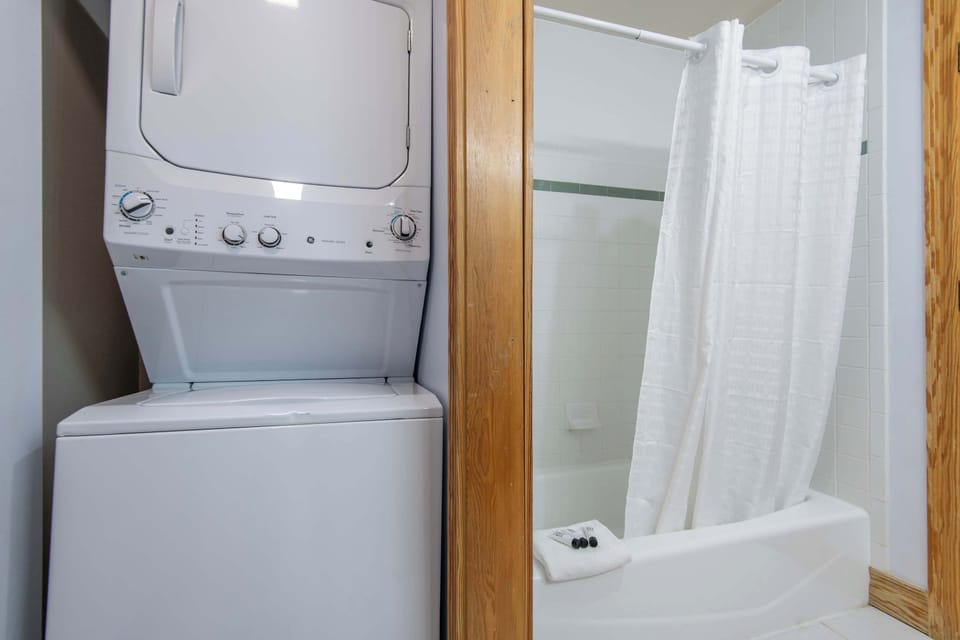 Primary bathroom with tub-shower combo and convenient in-unit laundry