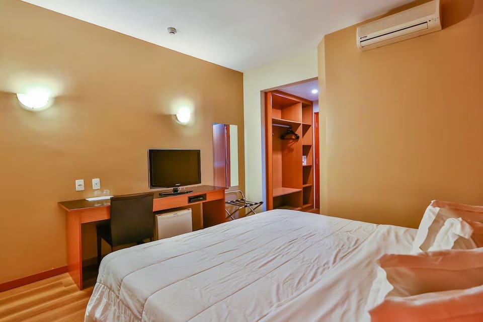 Recharge in air-conditioned comfort with desk and open wardrobe.