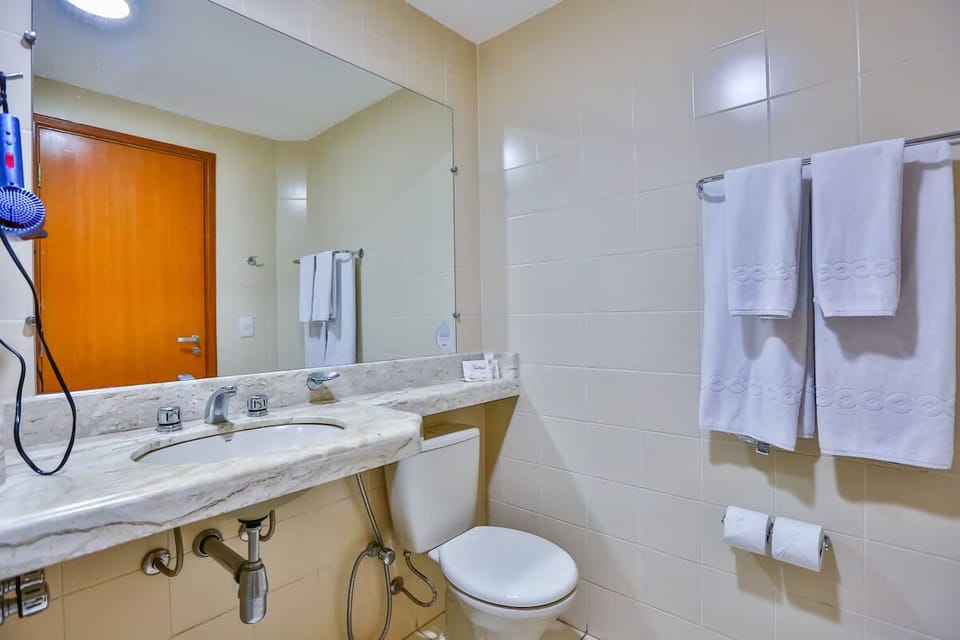 Refresh in a spotless bathroom with fresh towels and large mirror.