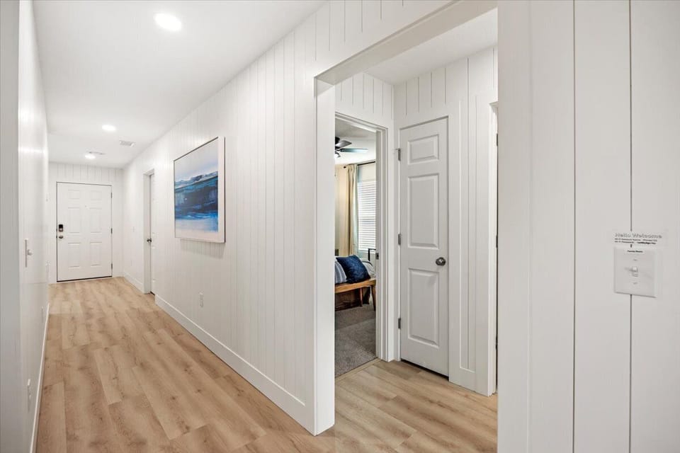 Bright & Airy Hallway w/ Shiplap Walls & Hardwood Floors Throughout!