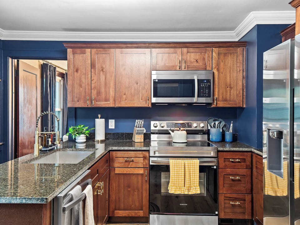 Kitchen w/ wood cabinetry, microwave & counter space ready for cooking together.
