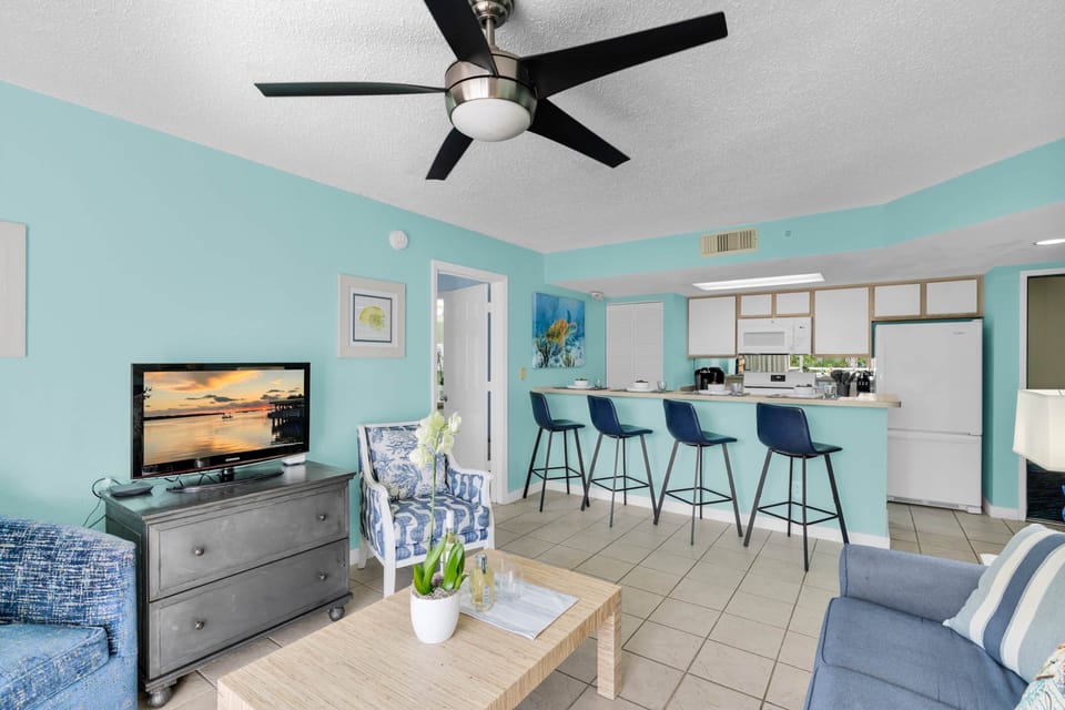 Relax in the open-concept living area with cable TV, cozy seating, and breakfast bar dining for four