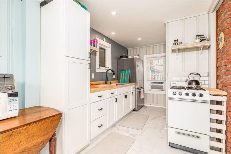 Kitchen with an oven, stove, full fridge, microwave, toaster and coffee maker