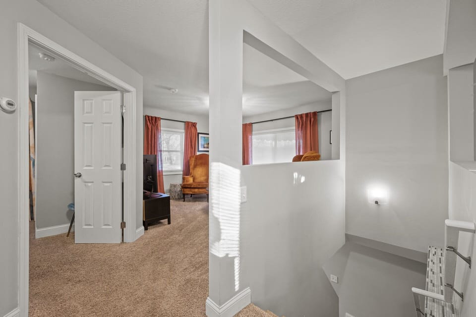Stair landing view w/ open rail details & a bright connection between levels.
