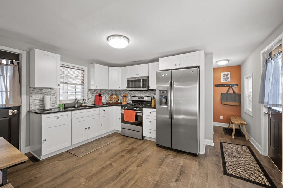 Clean, open kitchen w/ white cabinets, stainless appliances & plenty of space to prep meals together.