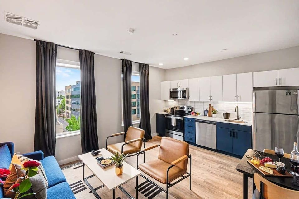 Bright and open living area featuring a smart TV and plush furnishings. Connects to the dining area and kitchen.