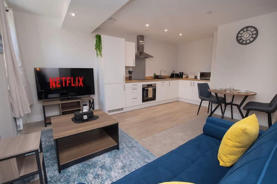 Unwind in our cozy living room featuring a smart TV for movie nights, with a spacious open-plan layout that flows seamlessly into the kitchen and dining area.