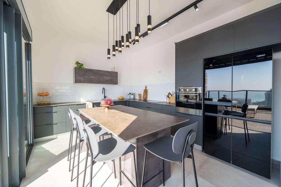 Statement island seating pairs designer lighting with panoramic outlooks.