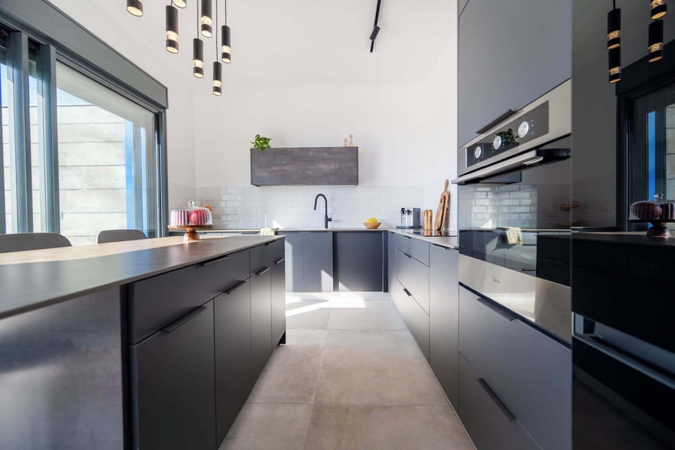 Sleek charcoal cabinetry and wide counters create an inspiring space for effortless cooking.