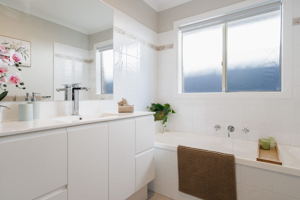Main bathroom with bath, shower, vanity, hairdryer and washer and dryer