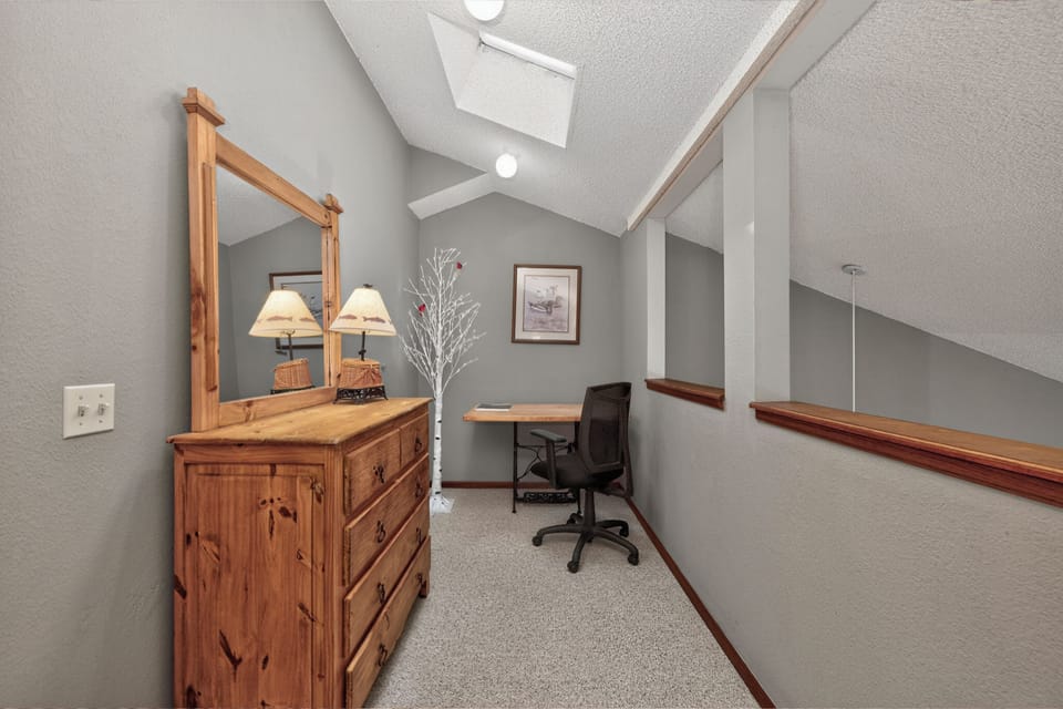 Your upstairs workspace features rustic wood furnishings and vaulted ceilings, perfect for catching up on emails or planning adventures.