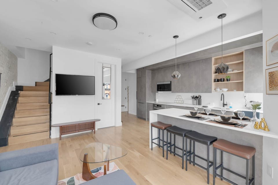 Modern multi-level home featuring an open kitchen, living area, and stairs.