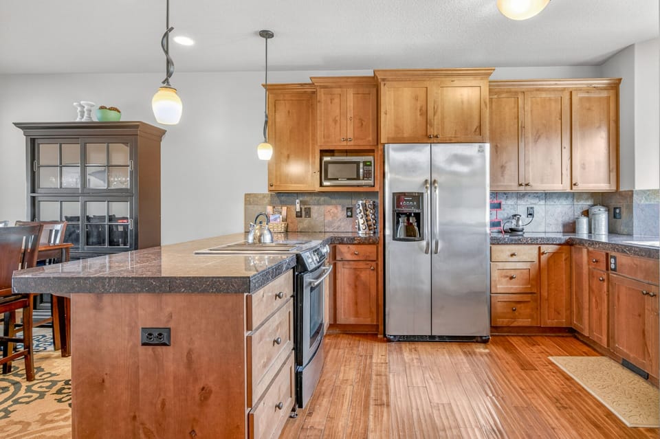 Your fully equipped kitchen features warm wood cabinets, granite counters, and stainless appliances - perfect for preparing memorable meals together.