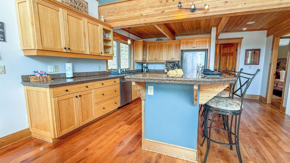 Your spacious kitchen welcomes you with warm wood cabinets, granite counters, and a breakfast bar where you can start each morning.