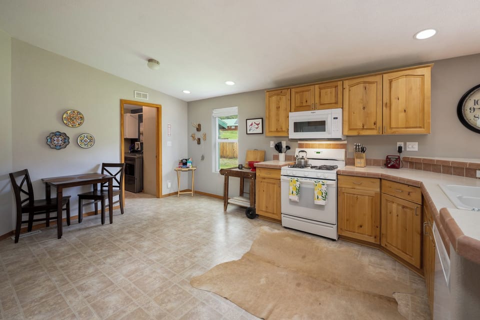 Gather in your fully equipped kitchen with warm wood cabinetry, modern appliances, and ample counter space for preparing meals together during your stay.