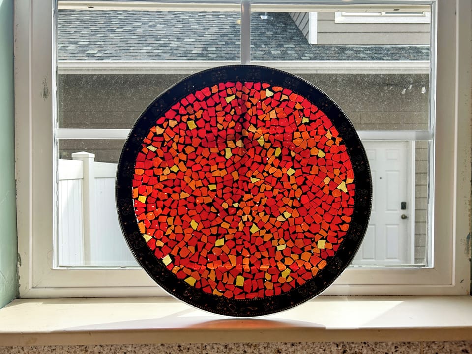 Admire this stunning handcrafted mosaic art piece, perfectly positioned to catch natural light streaming through your window.
