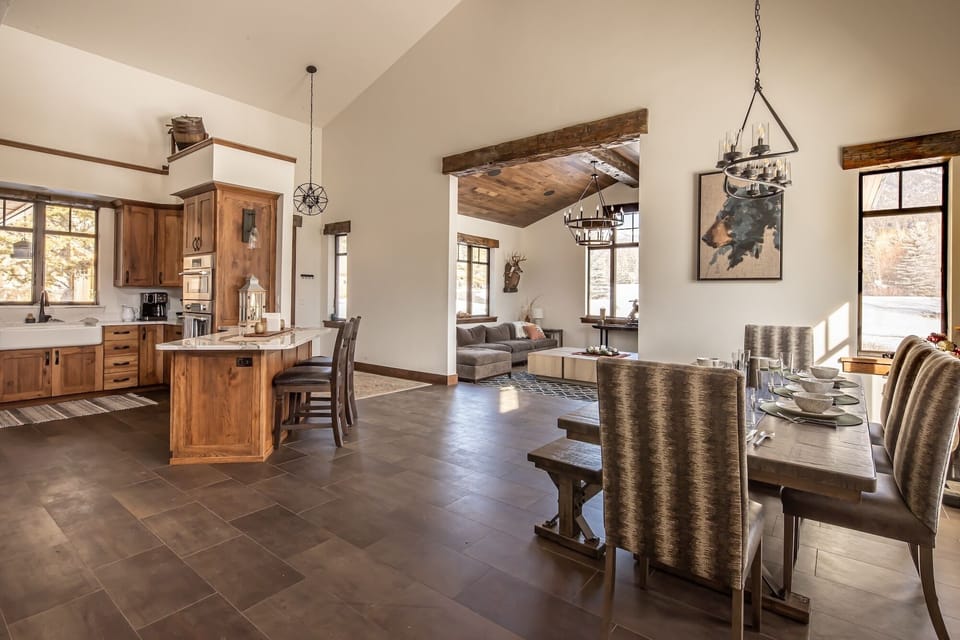 Gather around this stunning open-concept space where rustic wood meets modern elegance, perfect for cooking and dining together in style.