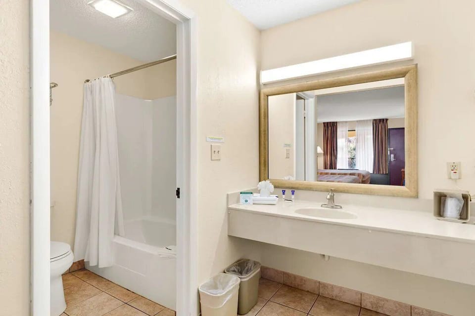 Step into a spotless bathroom with bright mirror lighting.