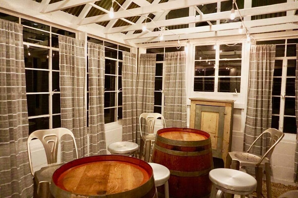 Dine under the stars in the enchanting greenhouse, where a cozy table for six awaits amidst twinkling lights and lush greenery
