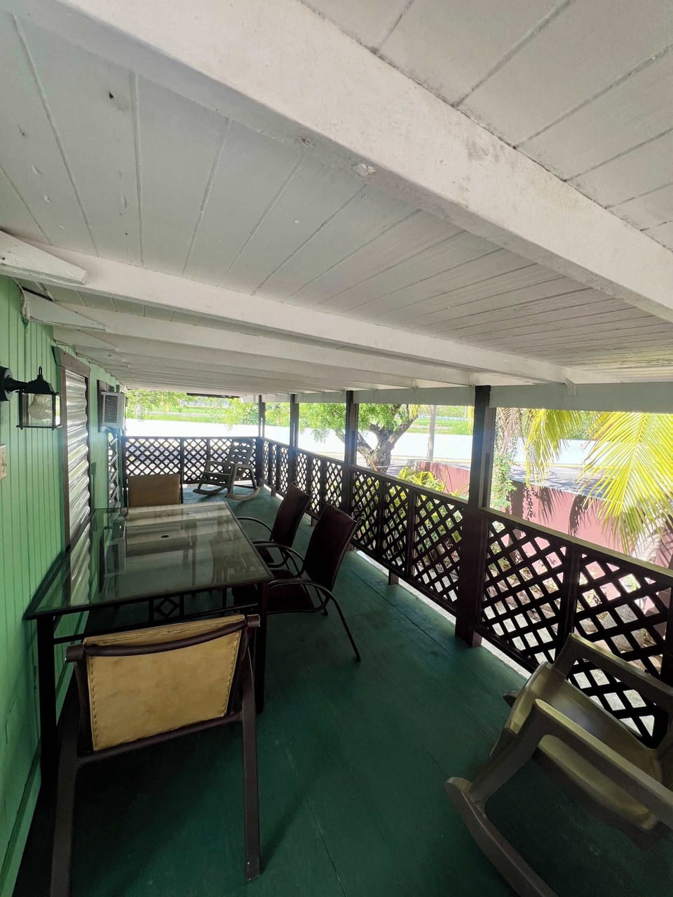 Spacious covered balcony with dining table and scenic views.
