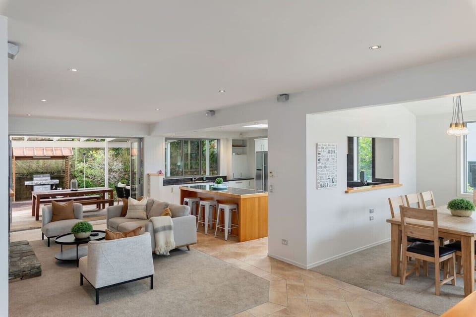 Cosy open plan kitchen, dining and living area around gas fireplace
