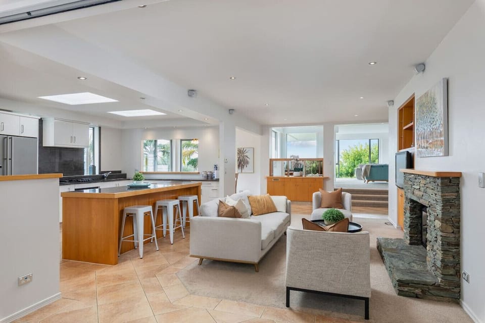 Cosy open plan kitchen, dining and living area around gas fireplace