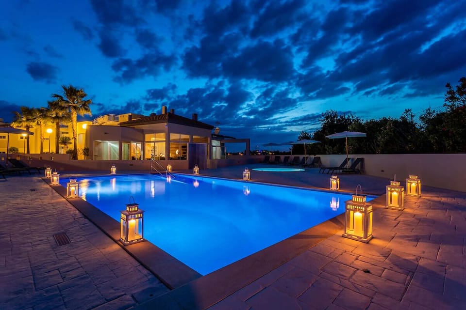 Unwind under lantern light in a sparkling evening pool.