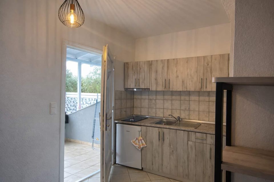 Kitchenette with countertop space and storage, positioned near the patio door.
