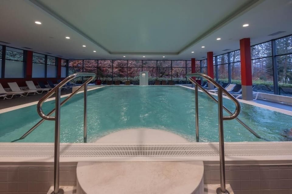 Dive into tranquil laps while trees frame the panoramic windows.