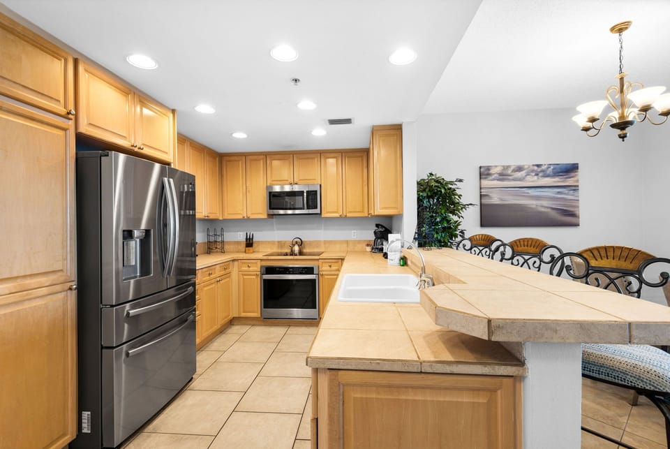 Large kitchen with ample counter space, modern appliances, and everything needed for family meals and beach vacations.