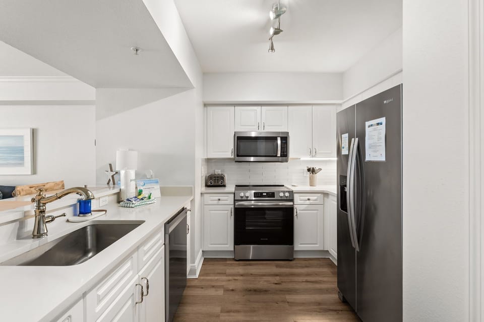 The fully equipped kitchen features quartz countertops, stainless-steel appliances, and has everything you need to prepare meals for family & friends.