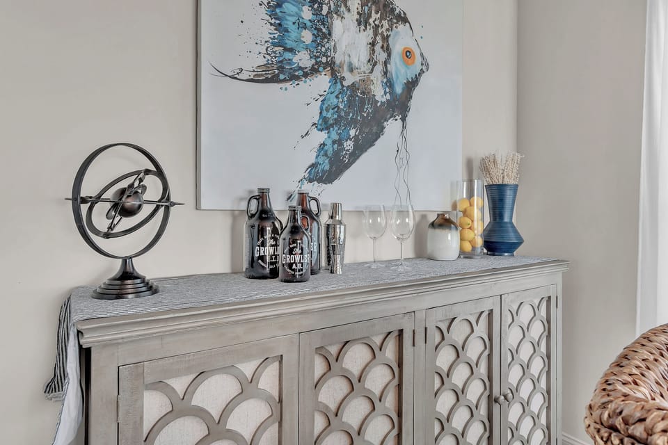 Style your drinks beautifully on this elegant sideboard, perfectly positioned beneath striking artwork for memorable evening toasts.