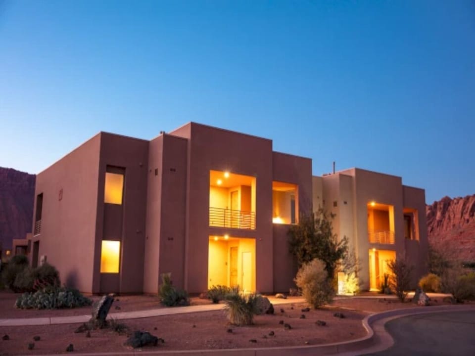 Arrive to glowing adobe architecture at peaceful twilight
