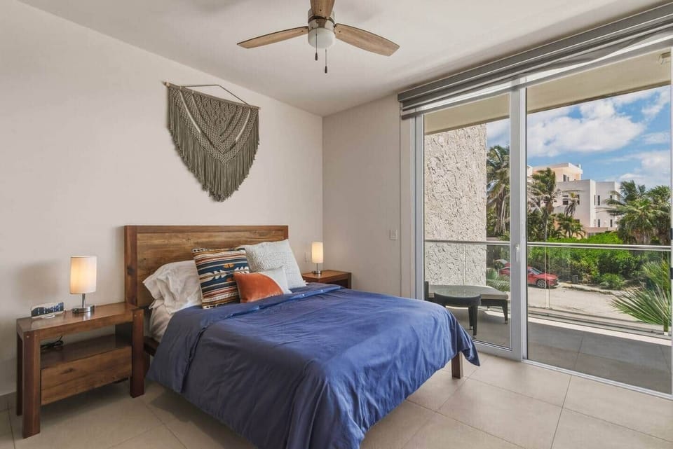 Cozy bedroom with a comfortable queen bed and direct access to your private balcony—perfect for enjoying the view and sea breeze. Includes A/C, ceiling fan, room-darkening shades, and bedside lamps with easy-access outlets for a restful stay.